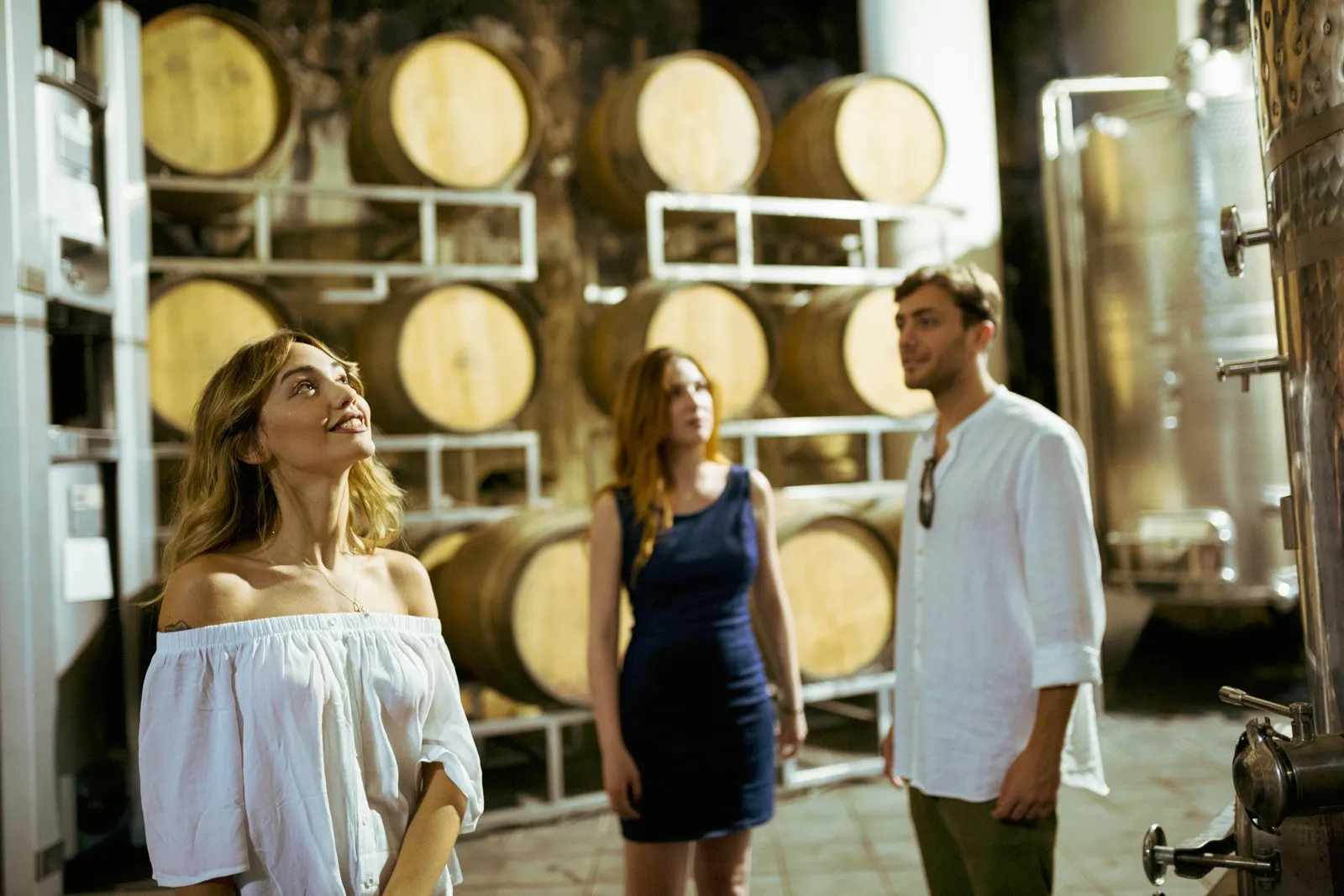 Guests among stacked barrels in the winery's ageing room
