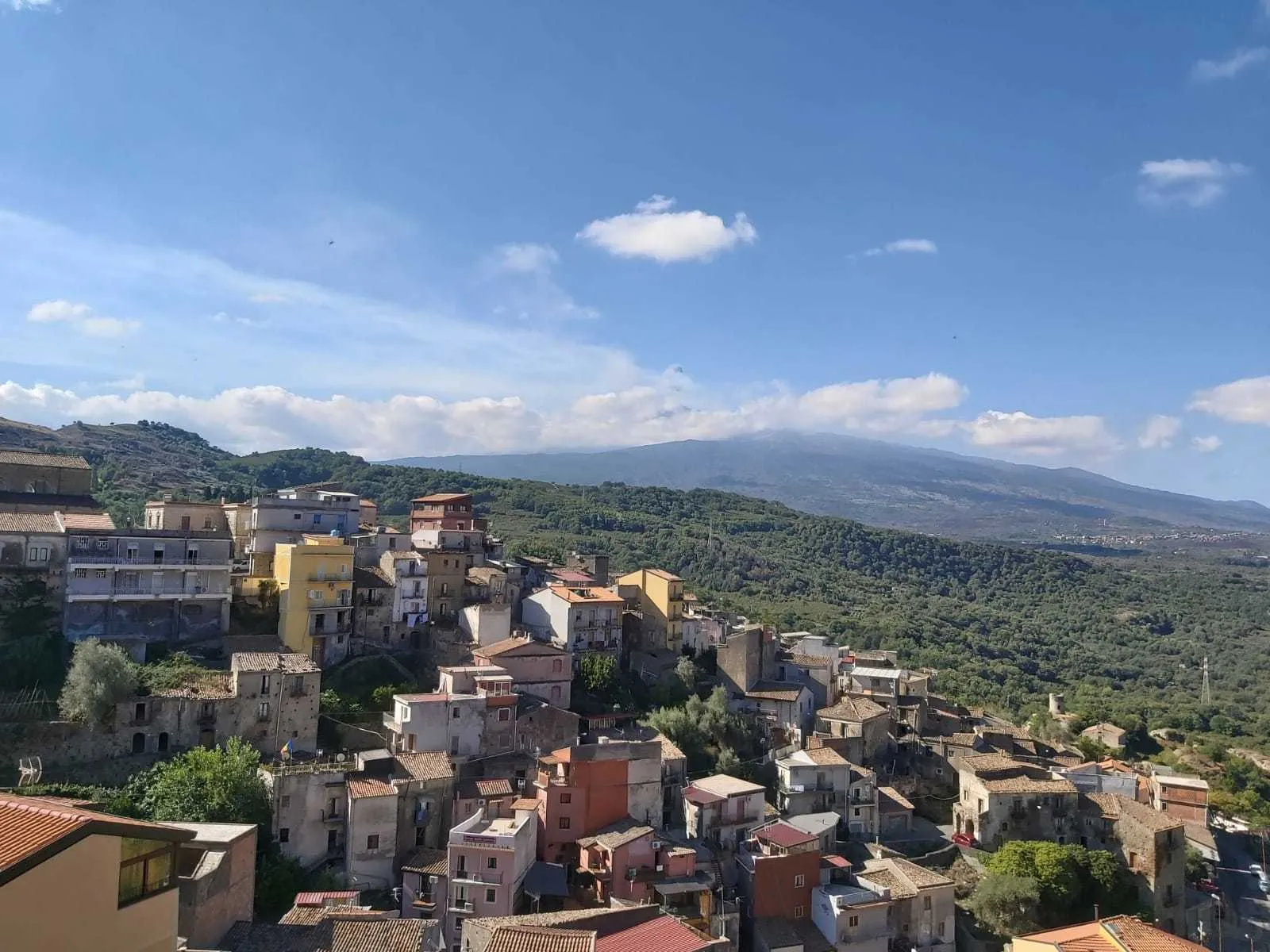 The rooftops of Castiglione di Sicilia stacked on their ridge with Etna behind