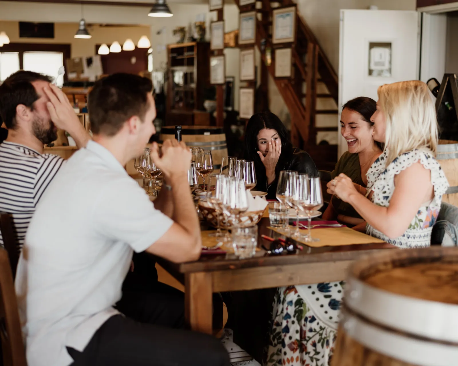 Guests laughing over glasses at the winery's tasting bar