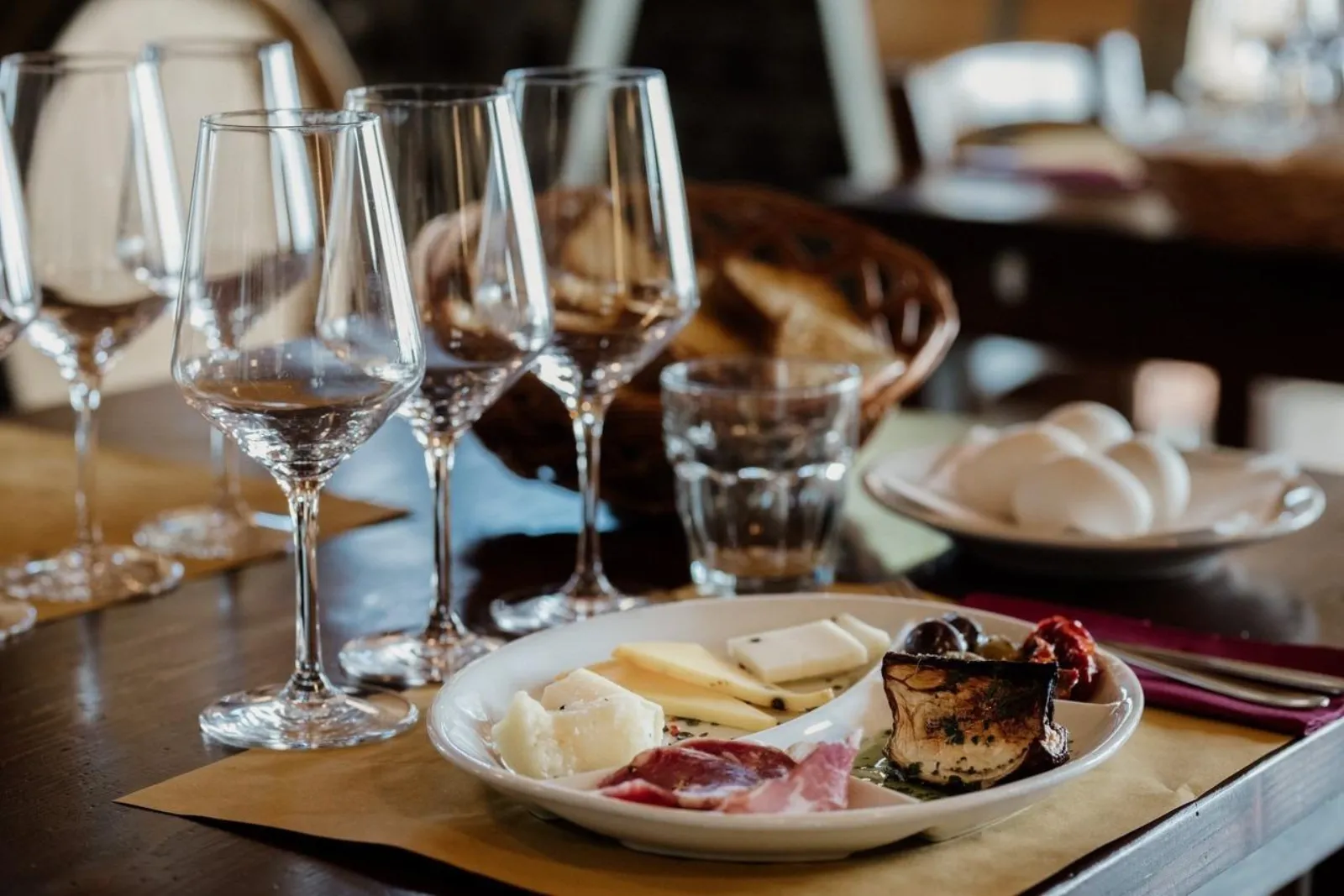A row of glasses beside a plate of cheese and dessert set for the pairing