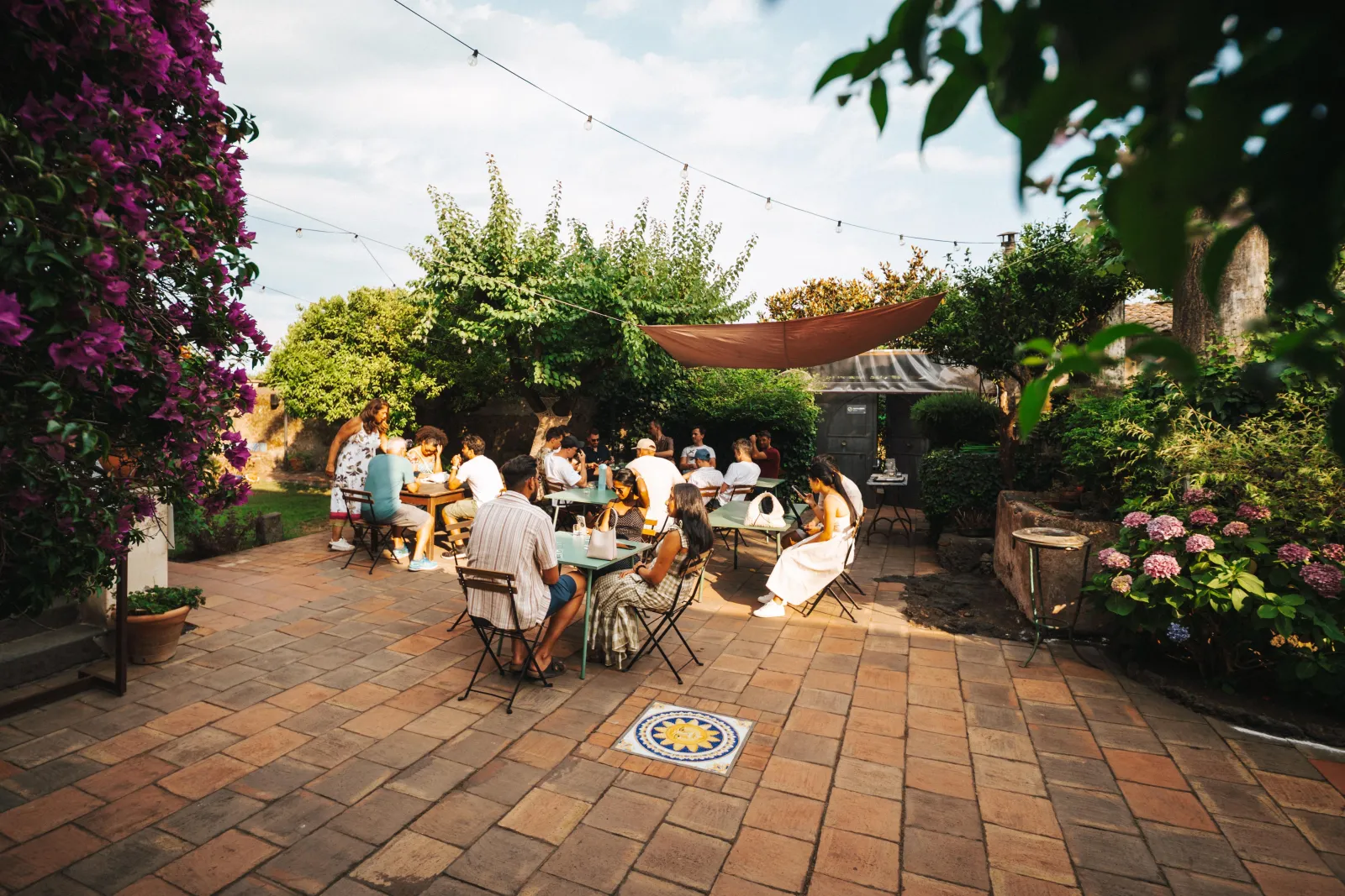 Courtyard tables under bougainvillea and string lights at the urban winery