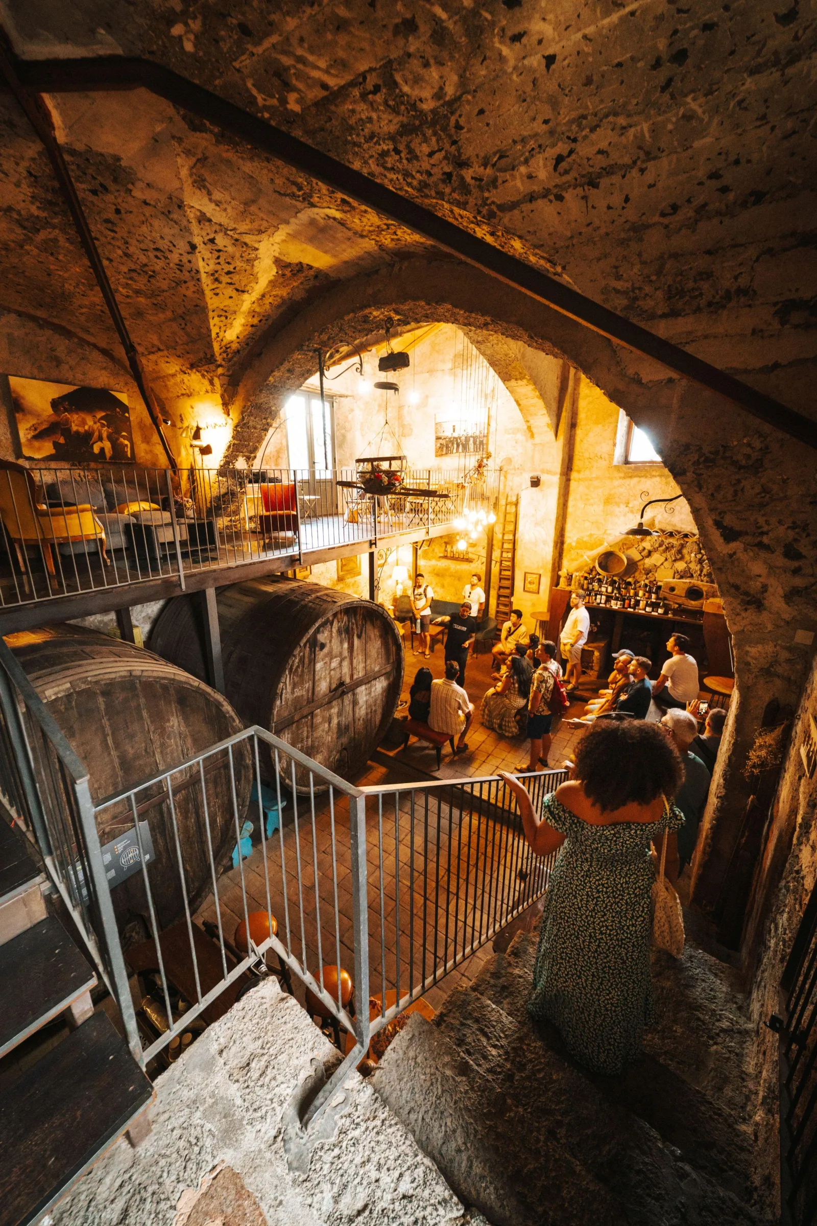 The vaulted stone cellar, barrels along the walls, now used as a dining room