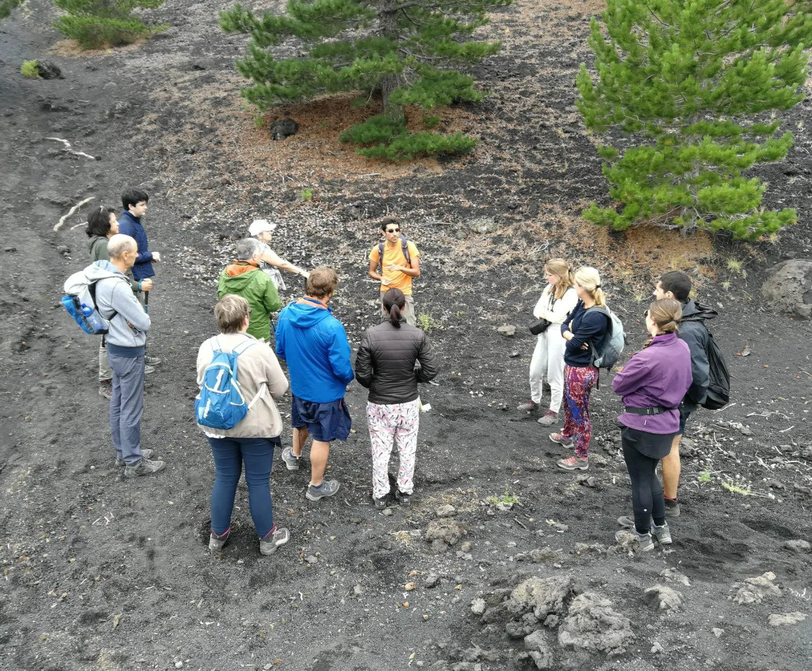A small group crossing grey ash fields on the guided crater walk